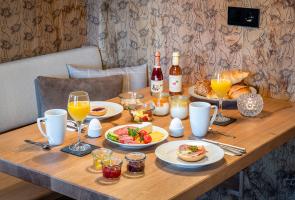 Regionales Frühstück in Ihrer Hütte serviert Gedeckter Frühstückstisch in Berghütte mit regionalen Produkten