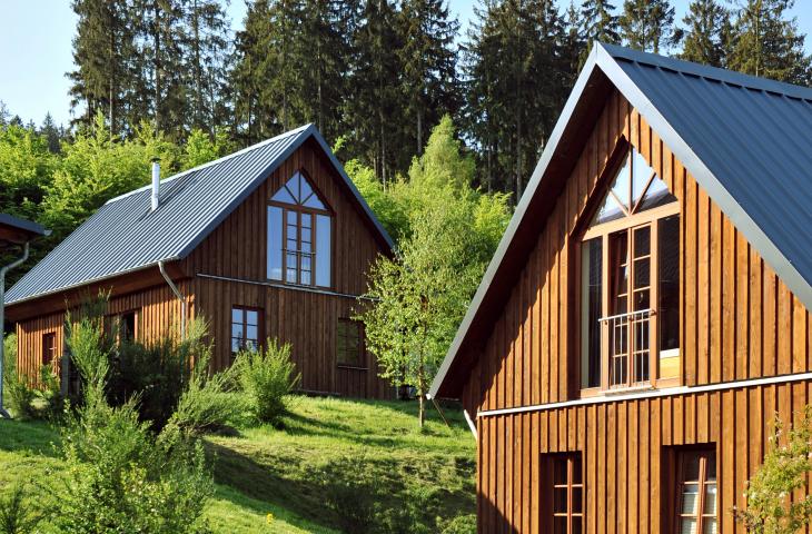 Gemütliche Berghütten im Bergdorf LiebesGrün Außenansicht Berghütten mit Bäumen und Natur.